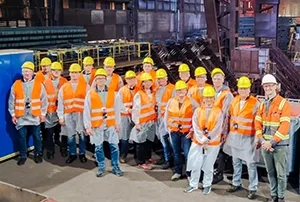 Die Teilnehmer einer Gruppe vor der Strangussanlage