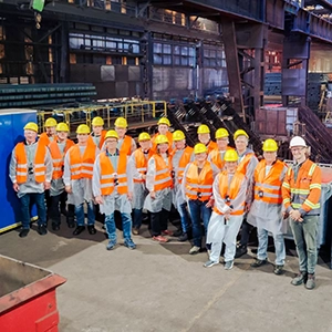 Die Teilnehmer einer Gruppe vor der Strangussanlage