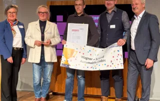 3. Platz in der Kategorie „SchuleWirtschaft - Kleine Unternehmen“: Samuel Wagner (Mitte) und sein Team erhalten den Leistungspreis für ihr Projekt „Schüler schrauben alte Autos in der Offenen Werkstatt Riesa“
